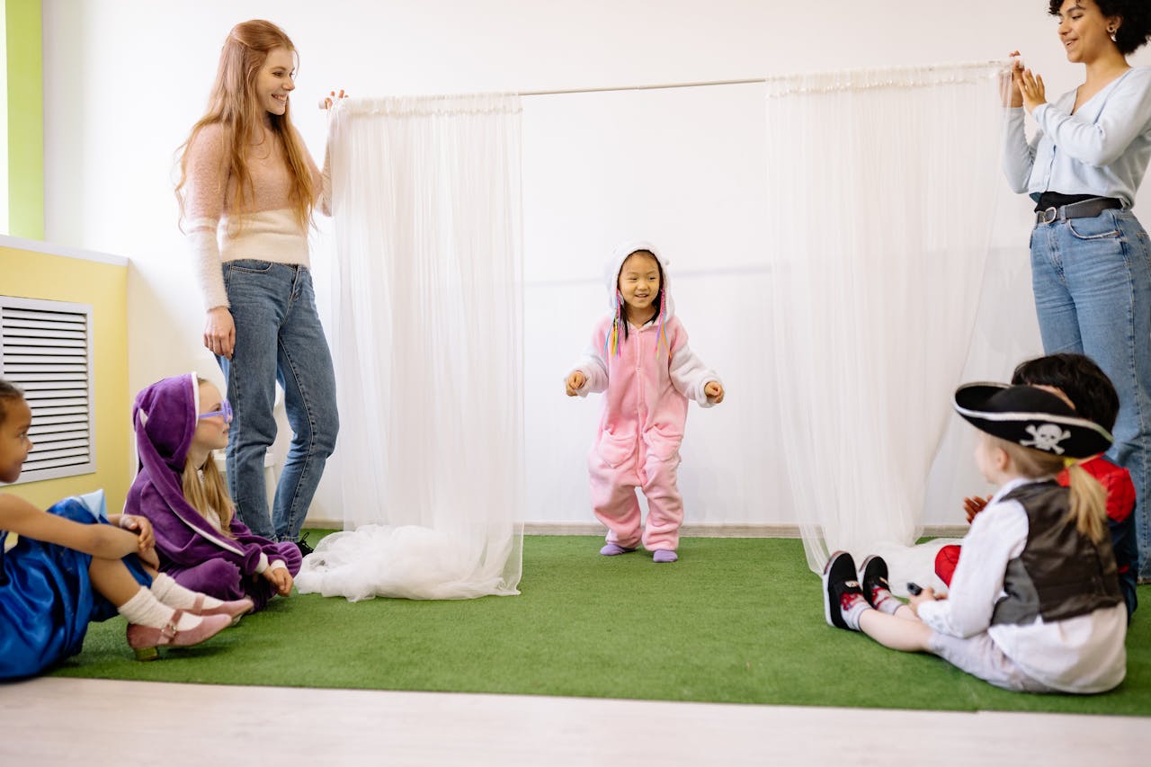 Kids in colorful costumes playing indoors with teachers facilitating a fun activity.